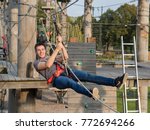 happy man having fun while using zipline at climbing park