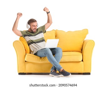 Happy Man With Headphones And Laptop On Sofa Against White Background