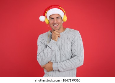 Happy Man With Headphones On Red Background. Christmas Music