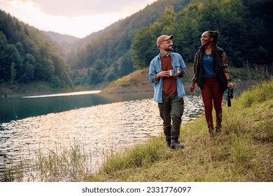 Happy man and his African American girlfriend walking by the lake in nature. Copy space. - Powered by Shutterstock