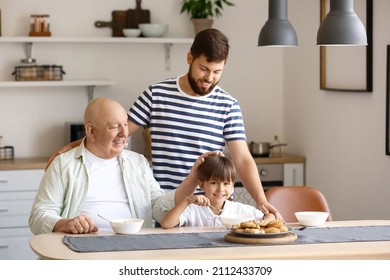 Happy man, his little son and father having breakfast in kitchen - Powered by Shutterstock