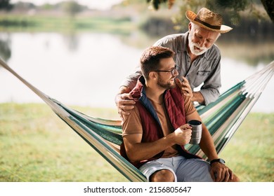 Happy man and his senior father talking and having fun while camping in nature. - Powered by Shutterstock