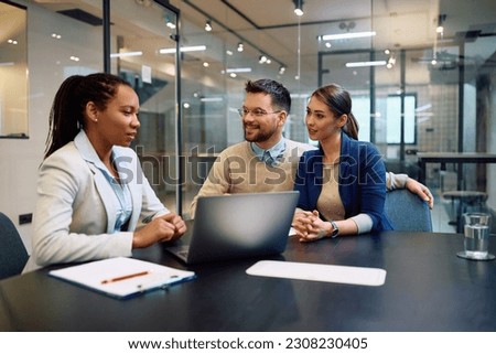 Happy man and his wife having counseling with their financial advisor in the office.