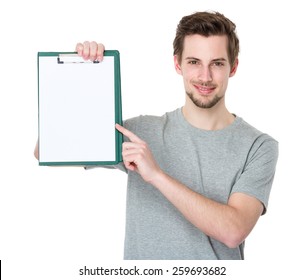 Happy man holding a clipboard and pointing with a finger