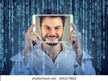 Happy man holding tablet with his face displayed on a screen isolated on binary code background 