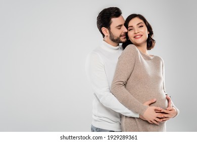 Happy man hugging cheerful pregnant woman isolated on grey  - Powered by Shutterstock