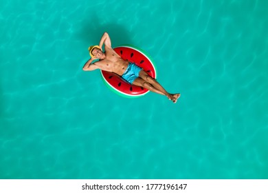 Happy Man With Inflatable Ring In Swimming Pool, Top View. Summer Vacation