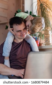 Happy Man With Joyful Children Using Laptop And Earphone During His Home Working While Sitting On Sofa At Home, Home Office With Together With Children, Life During Quarantine