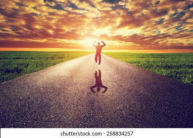 Happy Man Jumping On Long Straight Road, Way Towards Sunset Sun. Travel, Happiness, Win, Healthy Lifestyle Concepts.