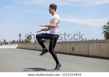 Happy man and jumping outdoors, warmup before jogging