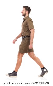 Happy man in khaki uniform walking. Full length studio shot isolated on white.