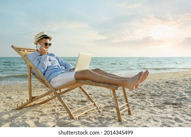 Happy man with laptop talking by mobile phone on beach. Business trip - Powered by Shutterstock