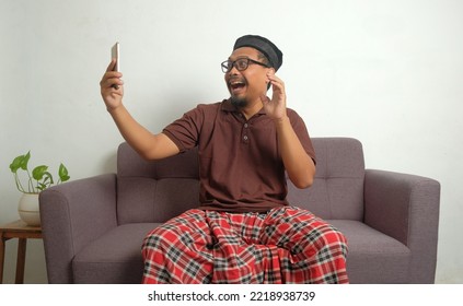 Happy Man Looking Phone Screen In Sofa