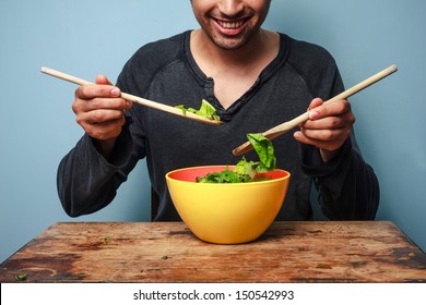 Happy man mixing salad with wooden spoons - Powered by Shutterstock