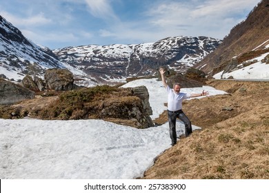 happy man on background mountains and snow-covered fjords. Norway in the spring