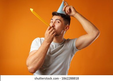 Happy Man With Party Cone Blowing Into Party Horn