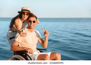 Happy Man With Physical Disability And His Girlfriend Taking Selfie At Sea Resort