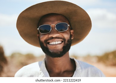 Happy man, portrait and safari travel outdoors for vacation, holiday and adventure to explore in South Africa. Face, smile and young black person hat, sunglasses and cool fashion for summer tourism