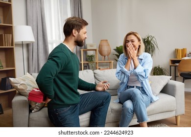 Happy Man Presenting Gift To Wife. Excited Young Man Presenting Good Unexpected Present To Wife At Home. Loving Boyfriend Making Romantic Surprise To Girlfriend  - Shutterstock ID 2244624923
