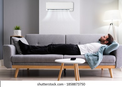 Happy Man Relaxing And Enjoying Cool Air Conditioner Or AC.