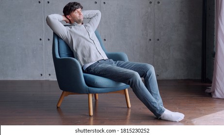Happy man relaxing on comfortable armchair, smiling calm relaxed guy lounge eyes closed in sunny cozy home.