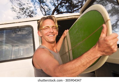 Happy Man Removing Surfboard From Of His Van