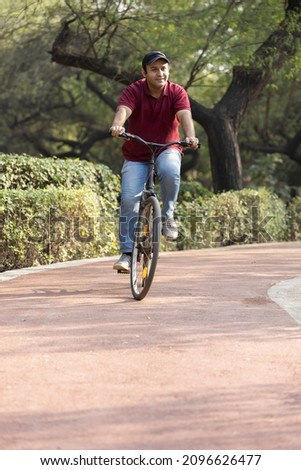 Happy man riding bicycle at park
