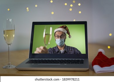 Happy man with santa hat making a toast on video call and celebrating christmas with glass of champagne during coronavirus or COVID outbreak. Second wave during xmas concept. focus on the laptop - Powered by Shutterstock