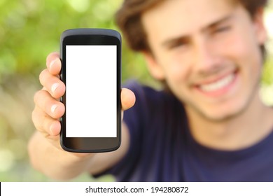 Happy Man Showing A Blank Mobile Phone Screen Outdoor With A Green Background            