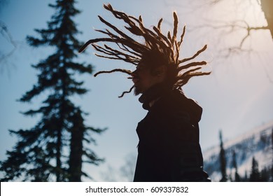 Happy man silhouette with windy dreadlocks in winter mountain forest - Powered by Shutterstock