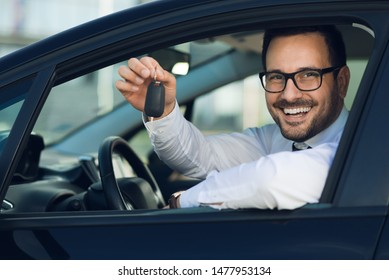 Happy Man Sitting In A Car And Holding New Car Keys