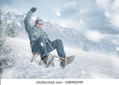 Happy Man Sledding Down A Slope In Winter