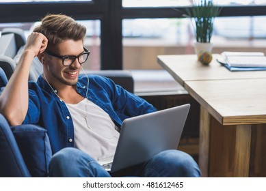 Happy Man Smiling In Front Of Laptop