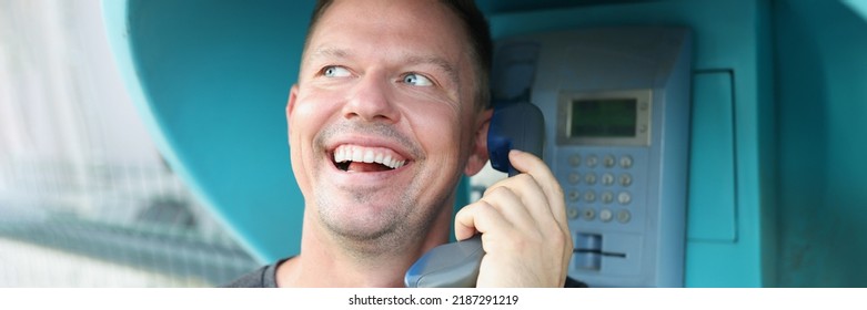 Happy Man Speaks On A Public Payphone On The Street, Close-up. Lack Of Mobile Connection, Phone Call In The Countryside