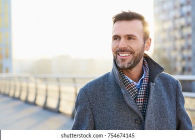 Happy man standing outdoors during sunny winter day - Shutterstock ID 754674145