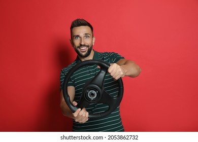 Happy Man With Steering Wheel On Red Background