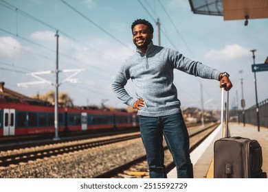 Happy man with suitcase standing on railway station. - Powered by Shutterstock