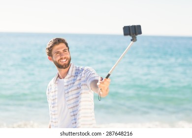 Happy Man Taking Selfie With Selfie Stick At The Beach