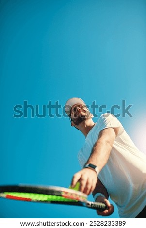 Happy man, tennis and racket with ball for serve, game or match start below blue sky background. Young, male person or athlete with smile for playing sport, competition or tournament on mockup space