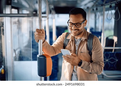 Happy man texting on mobile phone while commuting by bus.  - Powered by Shutterstock