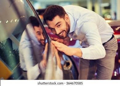 happy man touching car in auto show or salon