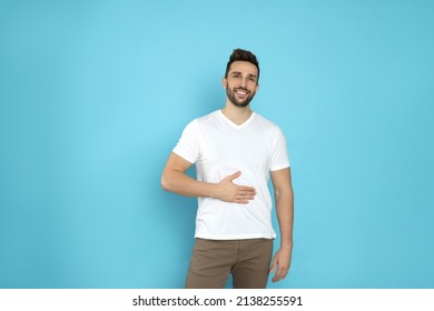 Happy Man Touching His Belly On Light Blue Background. Concept Of Healthy Stomach