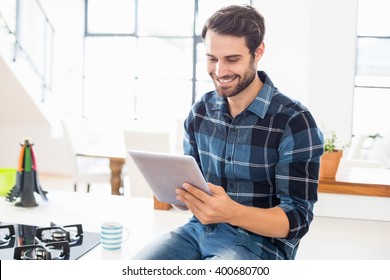 Happy Man Using Digital Tablet In Kitchen At Home