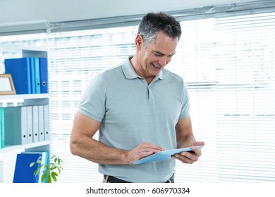 Happy man using digital tablet in office in office
