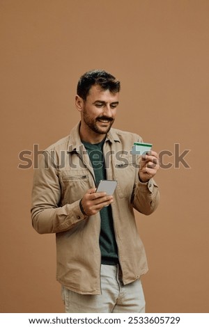 Happy man using mobile app and credit card for online shopping. Copy space. 
