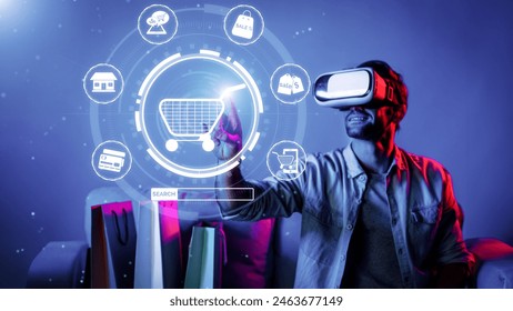 Happy man using VR headset and shopping online while sitting at sofa with shopping bags. Smart person looking at online market hologram and icon with neon background. Innovation technology. Deviation. - Powered by Shutterstock