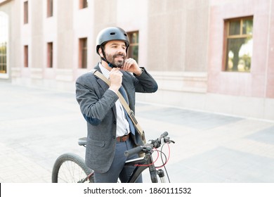 Happy Man Wearing A Business Suit Putting On A Helmet To Start His Bike Trip From The Office To His Home