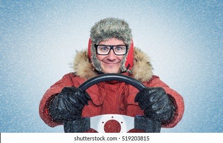 Happy Man In Winter Clothes With A Steering Wheel, Snow Blizzard. Concept Car Driver.