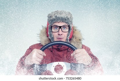 Happy Man In Winter Clothes With A Steering Wheel, Snow Blizzard. Concept Car Driver
