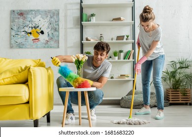 happy man and woman doing spring cleaning in apartment - Shutterstock ID 1681683220